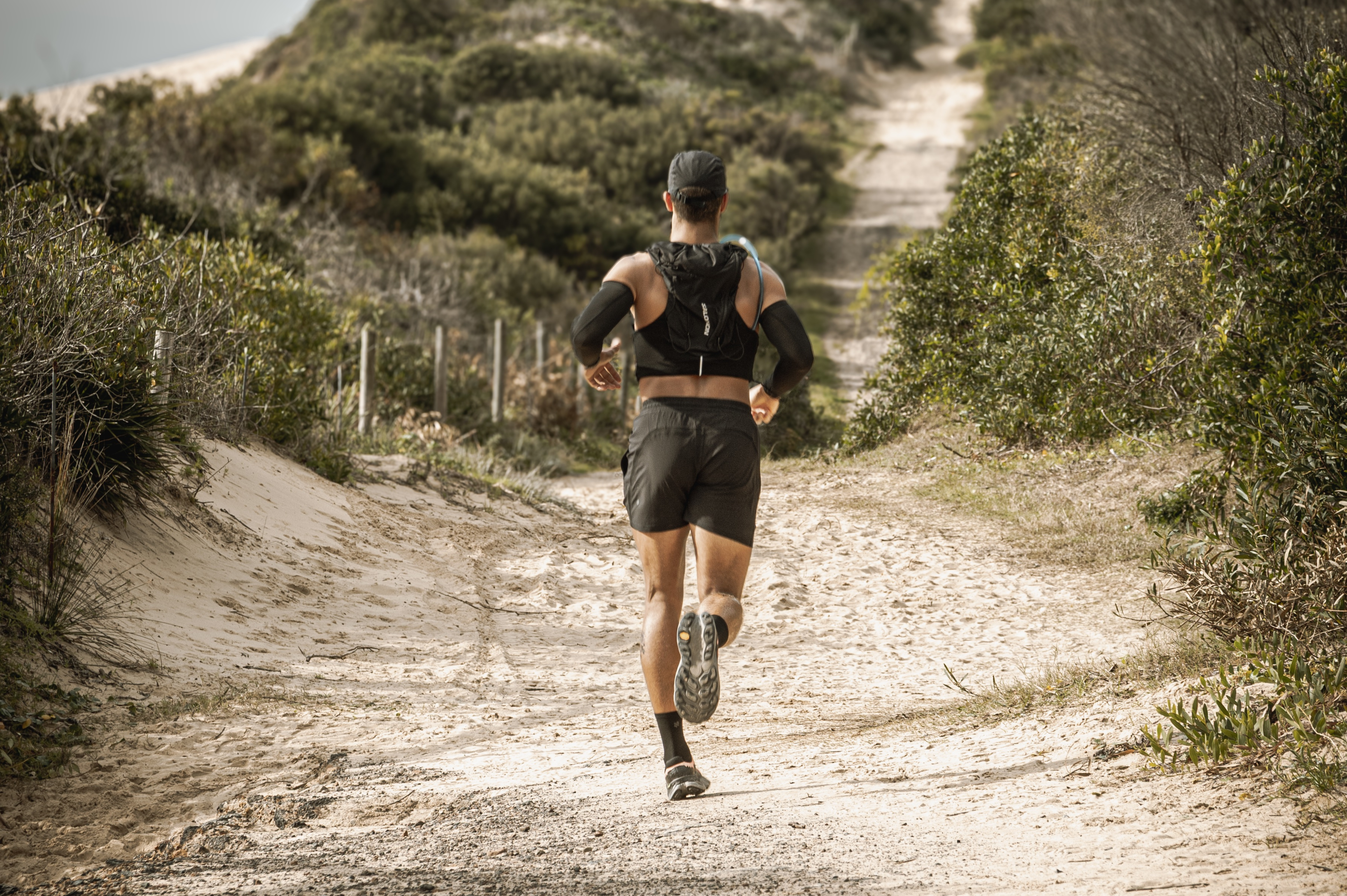 Man trail running through a sandy forest path wearing ruhn performance trunks and lightweight gear