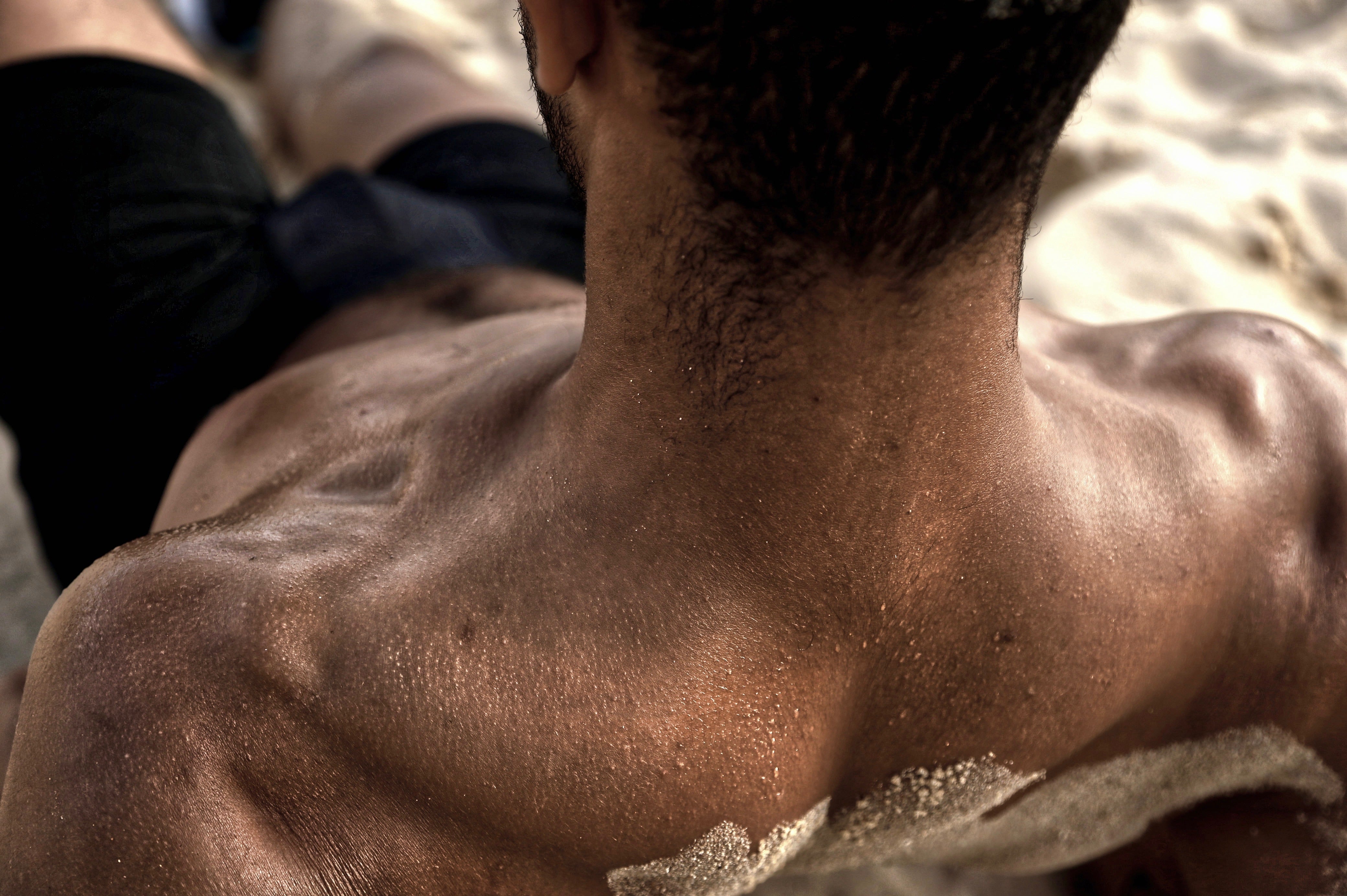 Textured close-up of athlete resting on the sand wearing ruhn performance underwear